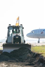 Haines & Kibblehouse, Inc.: A Caterpillar D5K grades stone as a American Airlines A321 heads towards its terminal.