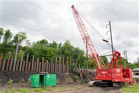 Structures Division: A Structures Division crew uses a Manitowoc 11000-1 crane and ICE hammer to drive sheet along the Amtrak mainline. 