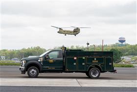 : A H&K Ford utility truck poses as a Chinook flies overhead.