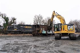 Haines & Kibblehouse, Inc.: A Caterpillar 335 excavator cuts up rail cars for recycling as Birdsboro Quarry's locomotives shift cars in the background. 