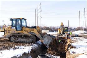 Haines & Kibblehouse, Inc.: A Caterpillar 963K track loader backfills a section of pipe as a pipe crew works ahead. 