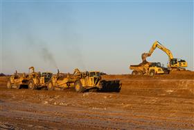 Pottstown Division: A pair of Caterpillar scrapers work along side a Komatsu excavator and haul truck. 