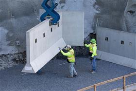 Structures Division: A Structures Division crew places precast concrete wall sections. 