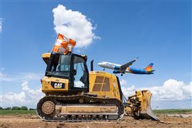 Lehigh Valley Division: A Caterpillar D5K II prepares for work as an Allegiant Airlines Airbus takes off.