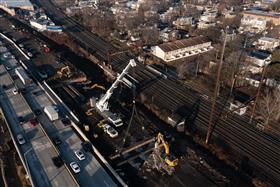 Haines & Kibblehouse, Inc.: A crane lifts an old bridge beam from a demolished structure as a Caterpillar 336F processes the concrete.