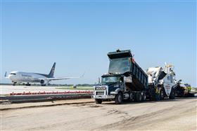 Haines & Kibblehouse, Inc.: A UPS cargo plane prepares for takeoff as a paving spread begins to pave at Philadelphia International Airport. 