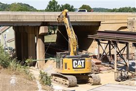 Structures Division: A Caterpillar excavator moves rebar onto the Huckleberry Road bridge project. 