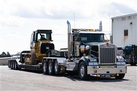 Pottstown Division: A Pottstown Division Kenworth W900L hauls a new Caterpillar 953 track loader to a job site. 