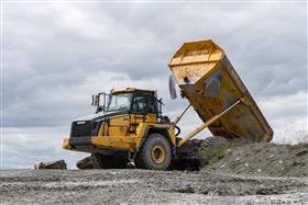 Hilltop Quarry: A Komatsu HM400 dumps shot rock into the primary crusher.
