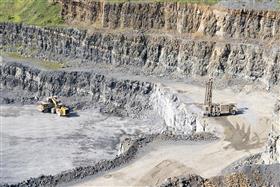 Naceville Quarry: A Caterpillar haul truck is being loaded with shot rock by a Caterpillar 988K on the bottom level while a drill rig begins to prep for the next blast on the shelf above.